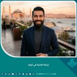 صورة مقربة لرجل وسيم بلحية كثيفة وطبيعية تمامًا بعد عملية ناجحة لزراعة اللحية في تركيا، يبتسم بثقة مع إطلالة بانورامية لغروب الشمس في اسطنبول والبوسفور وآيا صوفيا في الخلفية، تجسد الفخامة والنجاح.