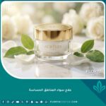 عبوة كريم فاخرة لعلاج سواد المناطق الحساسة موضوعة على رخام وسط بتلات الورد الأبيض كرمز للعناية والجمال.