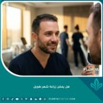 رجل ينظر في المرآة برضا بعد عملية زراعة الشعر الطويل مباشرة لرؤية النتيجة الفورية.