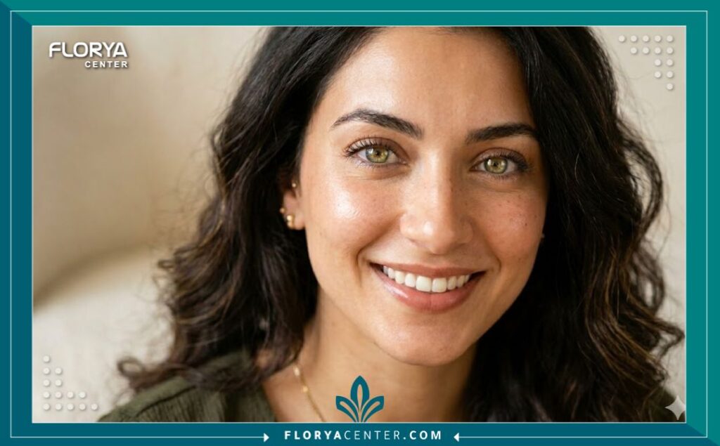 بورتريه جمالي لامرأة بعيون عسلية مخضرة فاتحة ولامعة بعد إجراء عملية تغيير لون العين بدون جراحة، تبرز النتائج الطبيعية والجذابة.