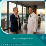 مريض يتحدث بثقة مع طبيب بعد إجراء عملية ناجحة لتحسين الصوت في عيادة بتركيا ويظهر مضيق البوسفور في الخلفية.