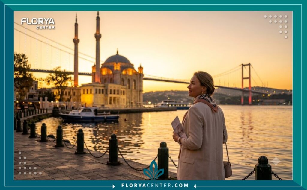 امرأة أنيقة ومرتاحة تتمشى على شاطئ البوسفور في اسطنبول عند الغروب، بعد رحلة علاجية ناجحة مع أفضل جراح تجميل عيون في تركيا، تجسيداً للسياحة العلاجية الفاخرة.