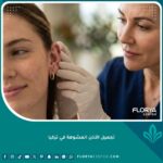 طبيب جراحة تجميل يفحص أذن مريض لتقييم حالة التشوه قبل عملية تجميل الأذن المشوهة في تركيا.