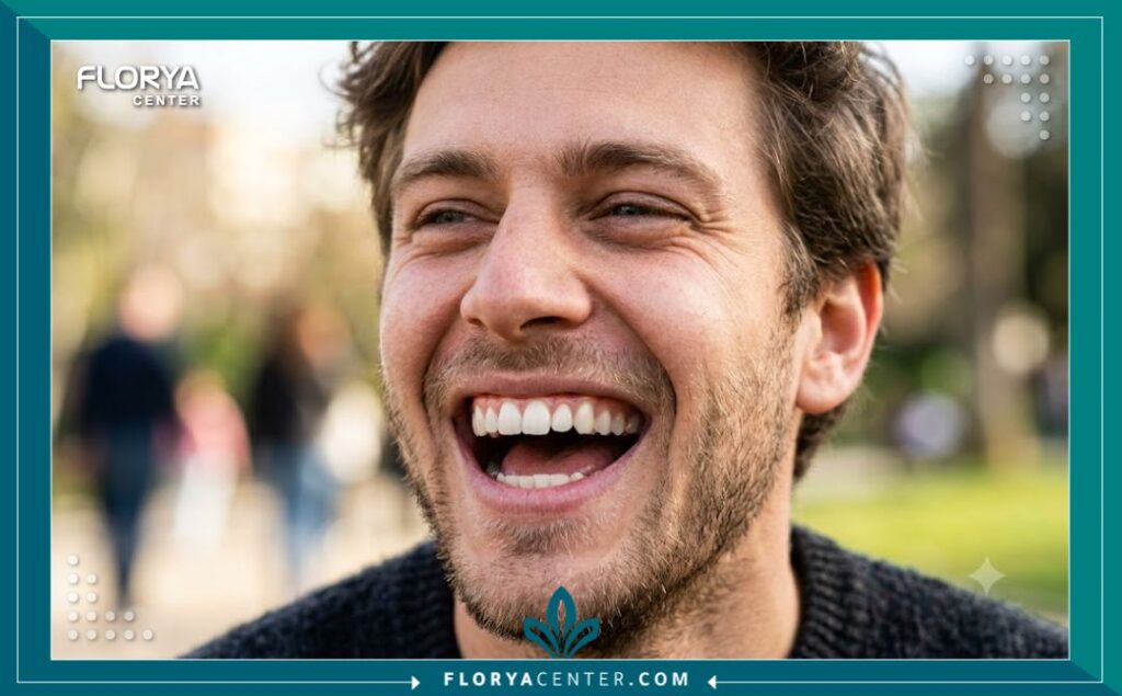 التقويم اللساني الداخلي 5 صورة قريبة لشاب يضحك بثقة تظهر تركيبة التقويم اللساني الداخلي المثبت خلف الأسنان بشكل مخفي وغير مرئي للآخرين.