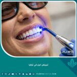 فتاة تبتسم بأسنان ناصعة البياض أثناء جلسة تبييض ليزر في تركيا داخل عيادة أسنان فخمة.