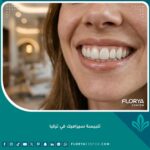 ابتسامة مثالية ومشرقة تظهر جمال ودقة تلبيسة سيراميك في تركيا لأسنان طبيعية.
