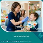 طبيب أسنان أطفال ودود يفحص أسنان طفل مبتسم في عيادة حديثة، خلع الاسنان اللبنية في تركيا بأمان.