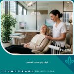 طبيب أسنان يطمئن مريضاً بابتسامة قبل البدء في خطوات كيف يتم سحب العصب في عيادة حديثة ومريحة.