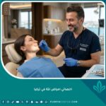 أفضل اخصائي امراض لثة في تركيا داخل عيادة أسنان حديثة يفحص مريضاً براحة تامة.
