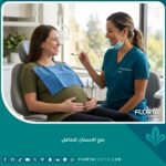 طبيبة أسنان تطمئن امرأة حامل وتبتسم لها قبل إعطاء بنج الأسنان الموضعي في عيادة حديثة لضمان أمان الجنين.