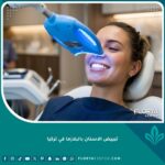صورة مقربة تظهر جلسة تبييض الاسنان بالبلازما في تركيا باستخدام جهاز الضوء الأزرق داخل عيادة أسنان فاخرة.