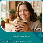 فتاة تبتسم براحة بعد تركيب التقويم، تشرب مشروباً دافئاً لتخفيف حساسية الأسنان بعد التقويم.