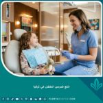 طبيب أسنان أطفال يبتسم لطفل في عيادة حديثة لعملية خلع ضرس الطفل في تركيا بدون ألم.