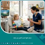 طبيبة أسنان أطفال تتعامل برفق مع طفل داخل عيادة حديثة توضح خدمة وسعر خلع السن اللبني في تركيا.