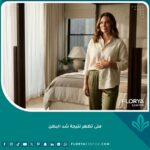 امرأة تنظر في المرآة بسعادة بعد ظهور النتيجة النهائية لعملية شد البطن وزوال الانتفاخ والتحجر.