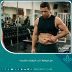 شخص محبط يمسك بترهلات البطن الشديدة أمام المرآة في النادي الرياضي بعد فقدان الوزن، مما يثبت عدم قدرة الرياضة على شد الجلد المترهل.