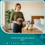 امرأة سعيدة وتتمتع بصحة جيدة تضع يديها على بطنها المشدود، تعبيراً عن الثقة بإمكانية الحمل والولادة بعد عملية شد البطن بأمان.